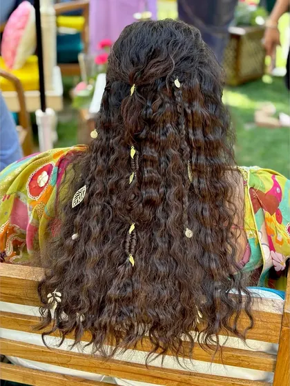 A bohemian-inspired hairstyle for a carnival event, with crimped waves, braids, and delicate leaf accessories.
