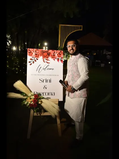 Posing by the welcome sign for a wedding celebration I hosted. I'm ready to make the event magical from the moment guests arrive.
