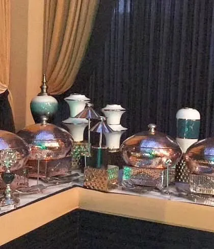 A straight-on view of the buffet corner, highlighting the beautiful contrast between the warm copper tones and the cool blue of the decorative vases.