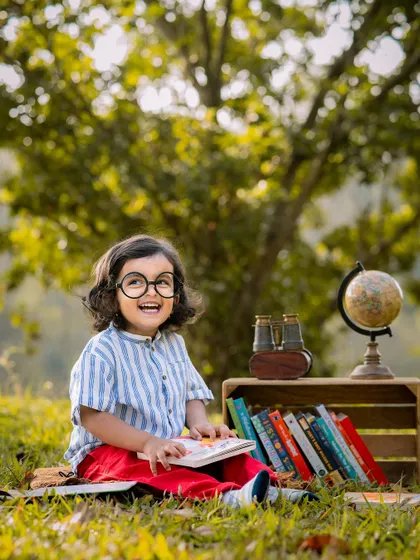 A little scholar enjoying a book in the park. We can bring any creative theme outdoors to take advantage of beautiful natural light.