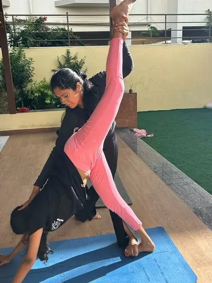 Helping a young dancer achieve a standing split. My workshops for performers focus on targeted stretches and strengthening exercises to enhance their flexibility and prevent injuries.