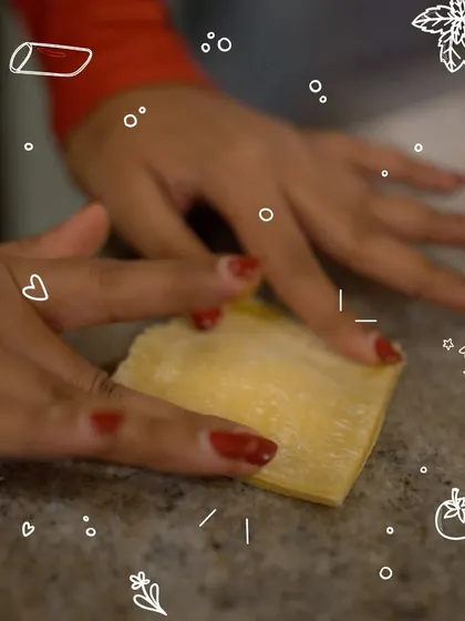 A participant carefully handles a delicate sheet of fresh pasta. This moment captures the focus and care that goes into crafting authentic pasta from just flour, water, and a bit of magic.