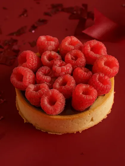 Sometimes, simple is most powerful. This shot uses a bold, monochromatic background to make the vibrant raspberries and the perfect tart shell pop. This artistic approach is great for high end bakeries and brands wanting a sophisticated, editorial look.