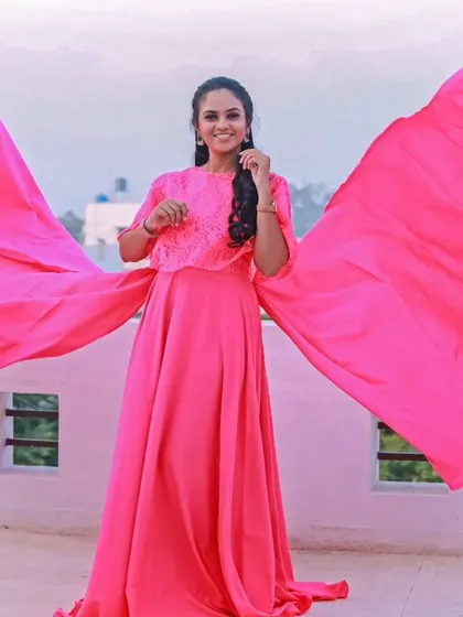 This bright pink gown features a lace capelet top and a dramatic trail, creating a butterfly-like effect for your photos.