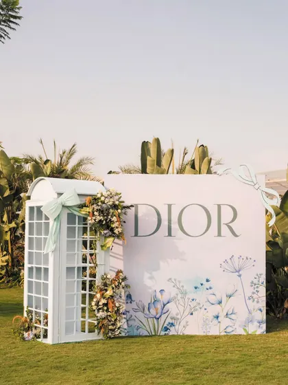 It's all in the details. For a chic Dior-inspired birthday, I designed and built this elegant telephone booth, adorned with soft florals. It’s a perfect example of how a unique, bespoke prop can elevate a theme and create a charming photo opportunity.