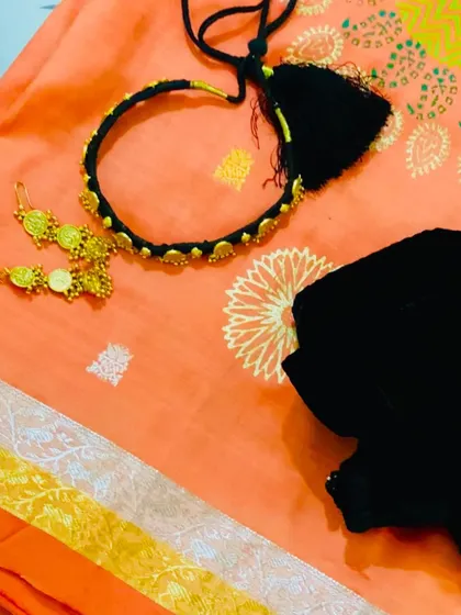 A styling close-up showing a black thread choker with gold accents. This modern piece adds a contemporary edge to a traditional Kanjeevaram saree.
