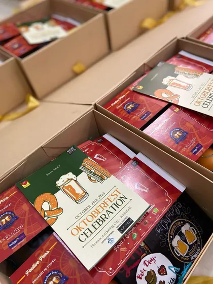 A look inside the Oktoberfest invite boxes, each containing event details and themed merchandise.