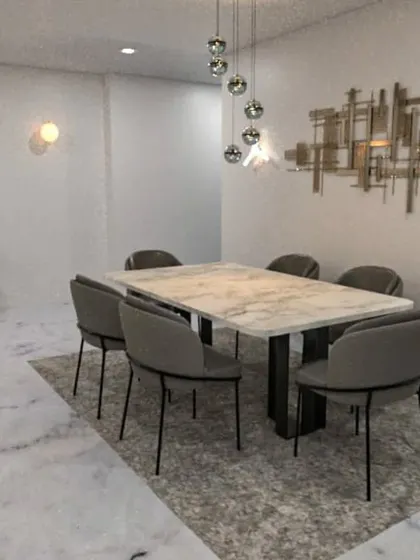 A concept for a modern dining area with a marble-topped table and striking metallic wall art.