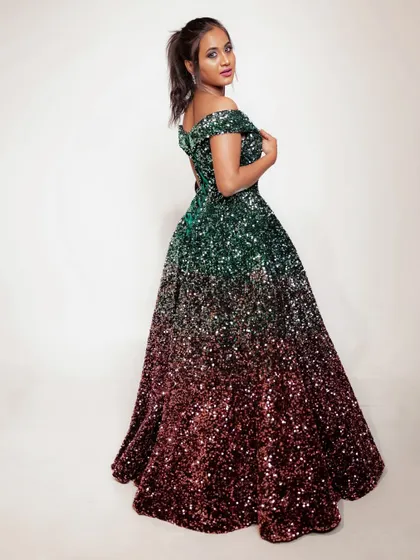 A full-length portrait against a clean white background, emphasizing the stunning silhouette of the sequin gown.