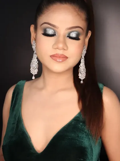Eyes closed to showcase the beautiful glitter and blending of the green and silver smokey eye makeup.