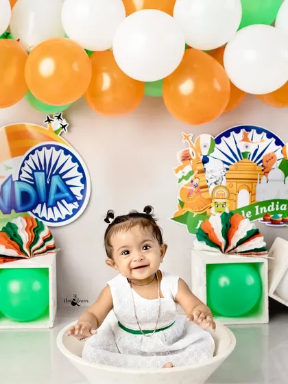 A happy smile from this little girl during her Independence Day themed shoot, surrounded by saffron, white, and green balloons.