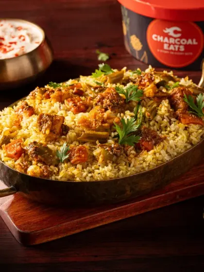 A hearty vegetable biryani from Charcoal Eats, ready for delivery. We style biryanis to look plentiful and aromatic, using garnishes and traditional serveware to enhance the visual appeal for online customers.