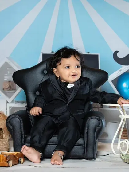 This little 'Boss Baby' is looking sharp in his black suit, ready to take over the world.