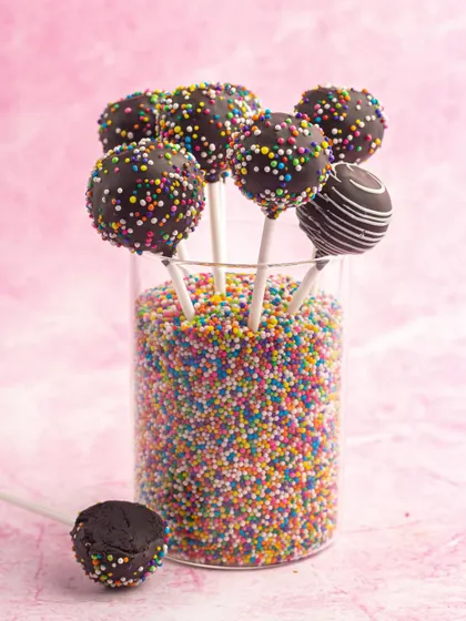 A fun display of my chocolate sprinkle cake pops. They are perfect for birthday parties and celebrations, adding a pop of color and sweetness to any dessert table.