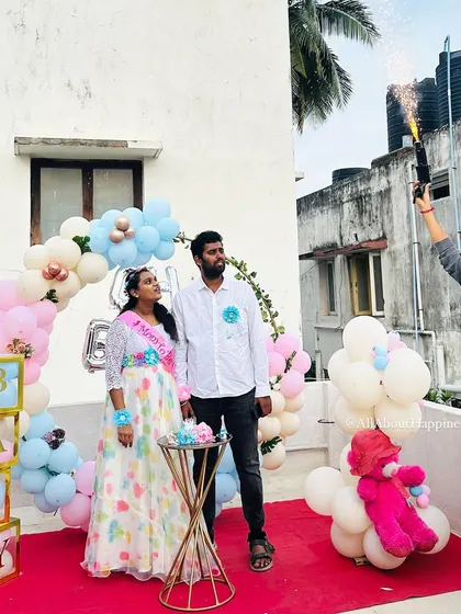 The moment of the gender reveal. The couple stands under the balloon arch as a cold pyro gun is fired, adding a spark of excitement to their special day.
