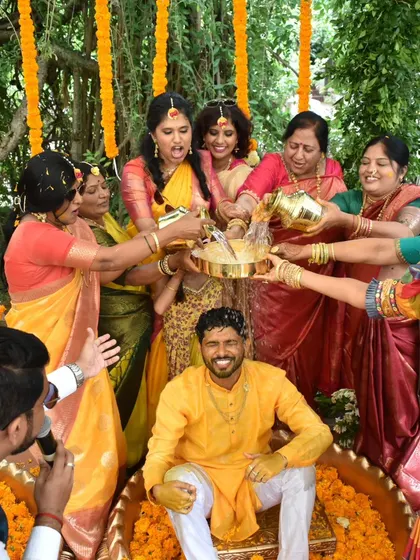 The ladies of the family showering the groom with holy water and blessings during the Haldi ritual. I guide these traditional moments with respect and joy.