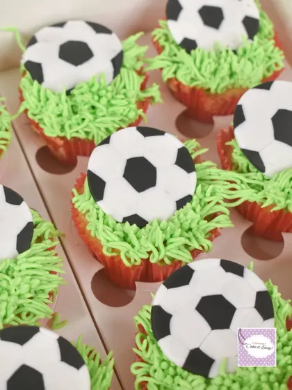 A closer look at the football cupcakes, perfect for party favors or as part of a larger dessert spread. The piped grass adds a fun texture.