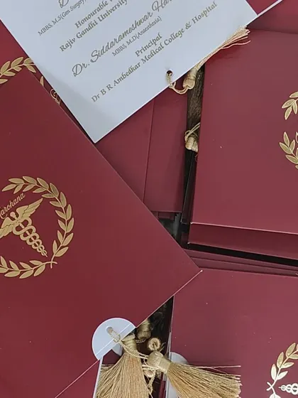 Another view of the graduation invitations, highlighting the deep red color and the shimmer of the gold foil.