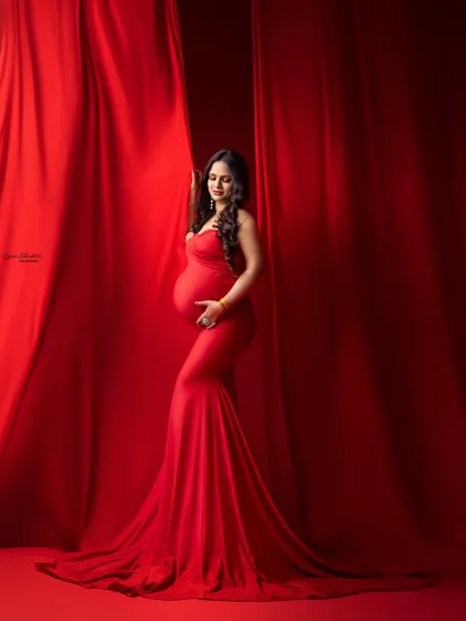The way the light hits the fabric and the gentle pose create a soft and elegant feel, even within such a bold and dramatic red-on-red setup.