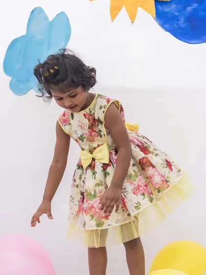A sunny yellow floral dress that's full of life. The tulle underskirt adds a fun, flouncy touch, perfect for a girl who loves to jump and play.