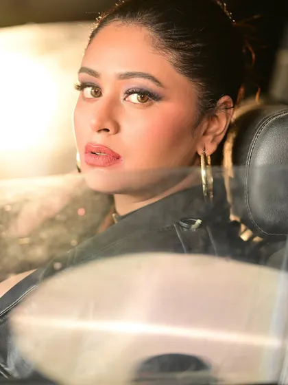 An intimate portrait of the model looking through the car window. The reflection and soft light create a moody and intriguing shot.