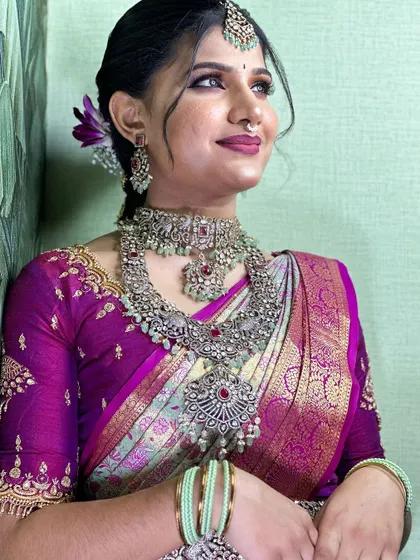 A close-up of the beautiful silver jewelry and makeup, perfectly complementing the colors of the silk saree.