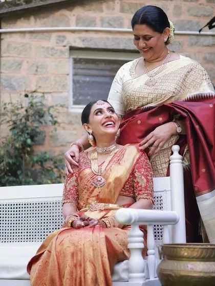A heartwarming moment between a mother and daughter. I had the pleasure of designing blouses for both of them, with the bride in a rich red and her mother in an elegant cream and maroon saree.