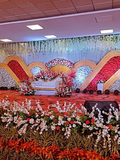A vibrant reception stage with a backdrop of red and white floral waves, creating a dynamic and celebratory look.