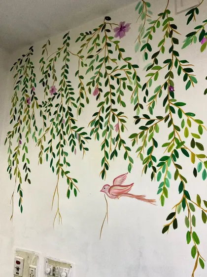A close-up of the hanging vines mural. The varying shades of green give the leaves depth, and the little bird adds a whimsical touch.