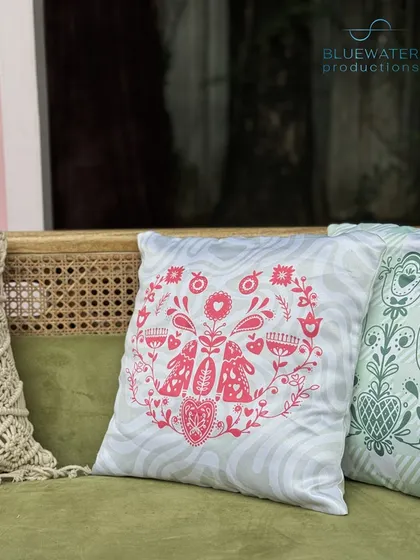 A close-up of the custom cushion, featuring a whimsical folk-art inspired design.