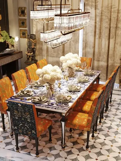 Our "jewel box" project was designed to impress from the moment you enter. The dining room features a rich color palette, intricate brass flooring inlay, and a collection of art, creating a luxurious, traditional, and Vastu-compliant space.