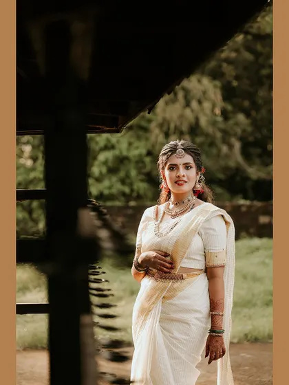 A stylish portrait of the bride in a traditional setting, framed in a warm brown border.