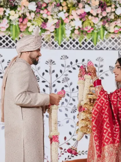 The Varmala exchange, a pivotal moment in the wedding ceremony, captured against our elegant Sheesh Mahal-inspired backdrop.
