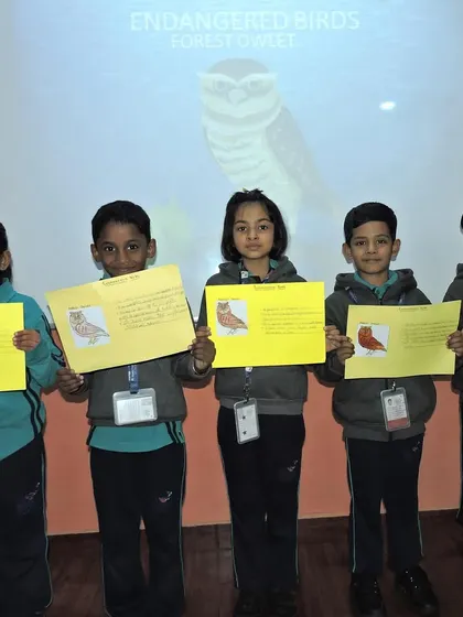 A group of students proudly display their completed projects on endangered birds, showing what they have learned about animal conservation.