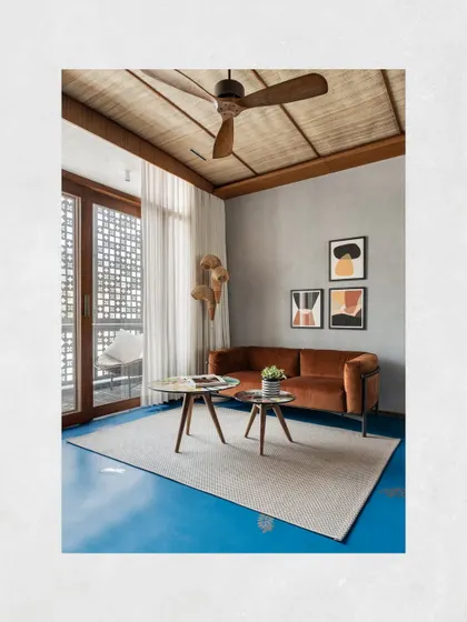 The private lounge area within the master suite of Kamala Residence, showing the seamless blue oxide flooring and the connection to a private balcony.