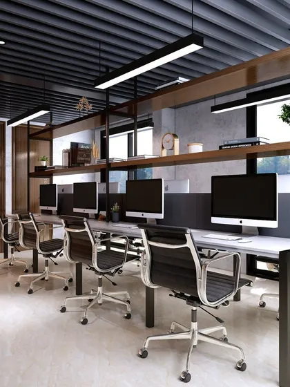 Another angle of the workstations, showing the use of linear lighting and a dark, exposed ceiling. The design is industrial yet refined, creating a productive environment.