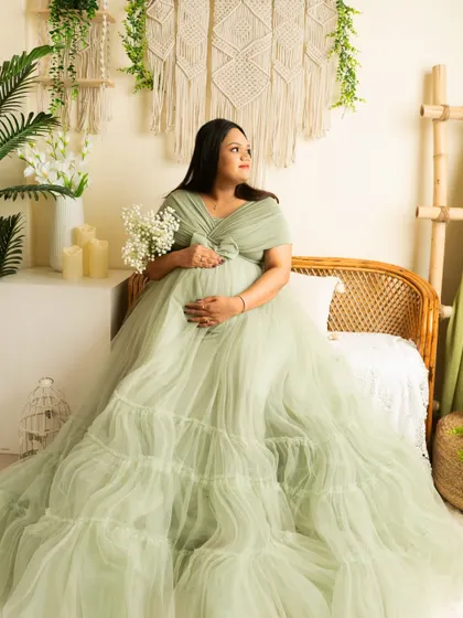A peaceful moment in the boho corner. The mother-to-be holds a bouquet of baby's breath, adding a delicate and natural touch.