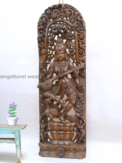 Our 72-inch masterpiece of the Goddess Saraswati, intricately carved with Jali (latticework) design. This large-scale wooden statue embodies wisdom and artistry, making it a profound centerpiece for any space dedicated to learning and culture.