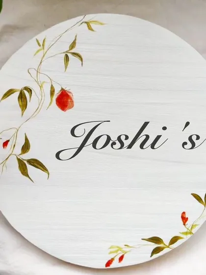 A minimalist circular nameplate with a delicate floral motif. The clean white background and simple design make it a sophisticated and timeless choice for any home.
