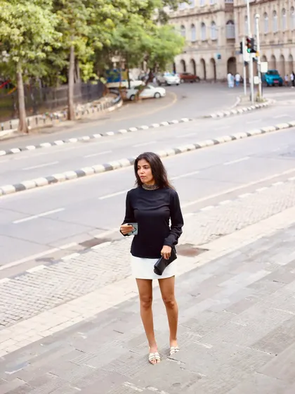 A full-length shot of the femme fatale outfit in a street setting, capturing a candid, on-the-move feel.