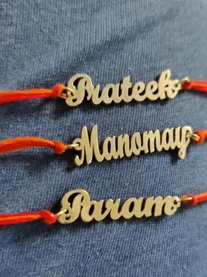 A set of three elegant rakhis with names cut out from metal in a beautiful cursive font.