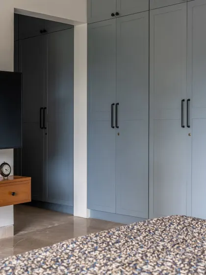 We used a cool blue-grey for the shaker-style wardrobes in this bedroom, providing ample storage while adding a touch of color. The clean lines and simple hardware maintain a classic, understated feel.