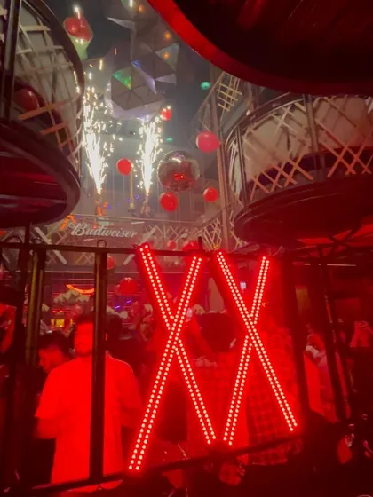 The sparklers add a celebratory feel to the intense red lighting of the club.