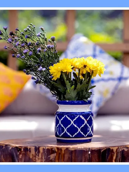 A close-up of a centerpiece. A beautiful blue and white ceramic vase holds bright yellow chrysanthemums, perfectly capturing the theme's color palette in a small, elegant detail.