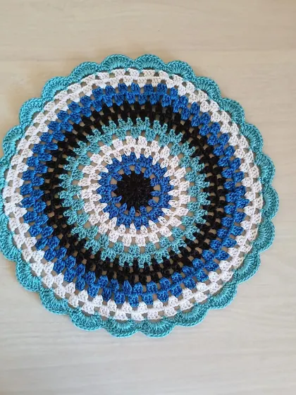 This elegant centerpiece features a mesmerizing pattern of concentric circles in shades of blue, black, and white. It's a modern design that can be customized in any color palette.