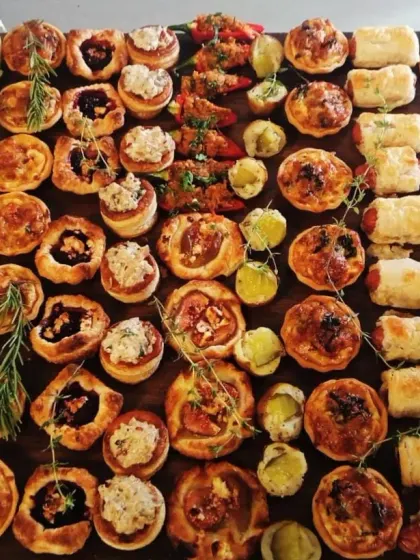 Sliders, quiches and savoury pastries sit in rows on our party board, with little flowers tucked between the bites.