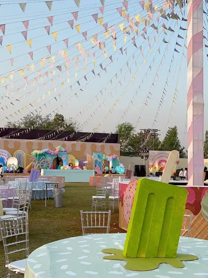An overview of the Candyland setup, with popsicle centerpieces and colorful bunting creating a festive carnival atmosphere.