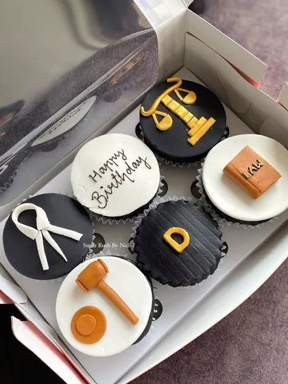 Cupcakes for a lawyer's birthday. This set features fondant toppers shaped like a gavel, law book, and scales of justice for a fun, professional theme.