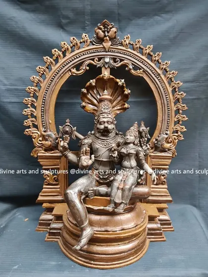 The wax model for a Lakshmi Narasimha sculpture, framed by an ornate Prabhavali arch. The entire composition, including the serpent Adishesha's hood, is first realized in wax.