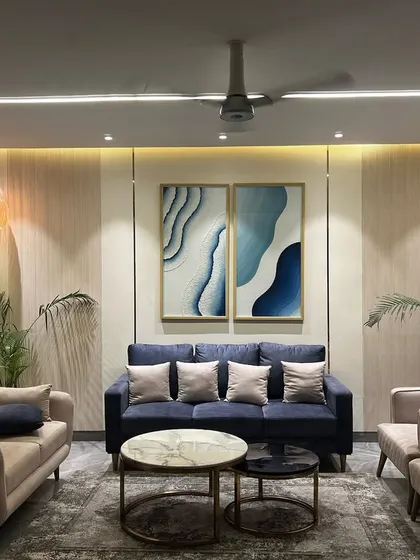 This living room in Jaypee Greens, Noida, embodies my design philosophy. I focused on creating a serene and sophisticated space using a neutral color palette with a bold blue sofa as the focal point, complemented by abstract art. The layout is designed for both relaxation and social gatherings, featuring comfortable seating and layered lighting to create a warm, inviting atmosphere.